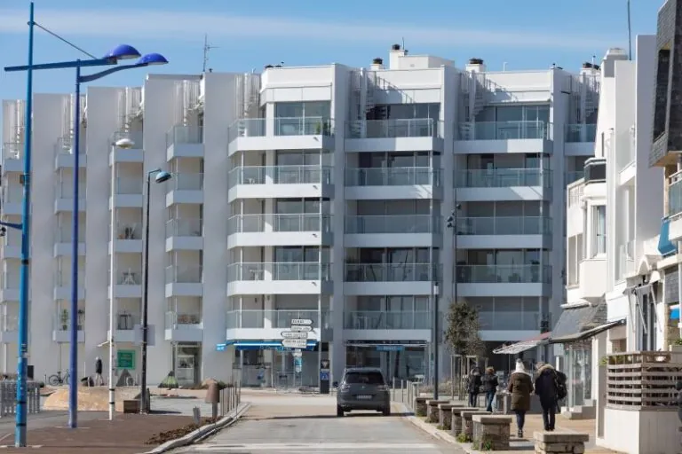 immeuble en bord de mer avec des garde-corps vitrés, vitrage clair, modèle prêt à poser avec doubles poteaux intermédiaires et habillage de la dalle avec un bandeau en aluminium
