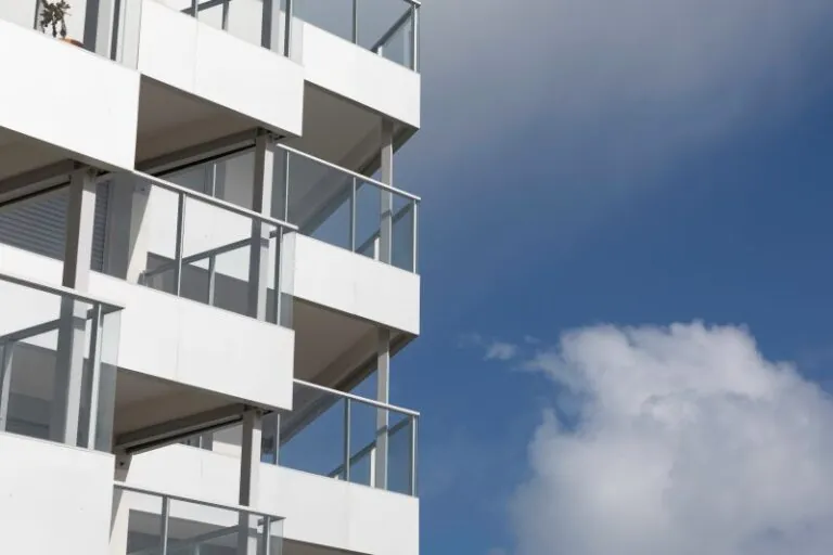 immeuble en bord de mer avec des garde-corps vitrés, vitrage clair, modèle prêt à poser avec doubles poteaux intermédiaires et habillage de la dalle avec un bandeau en aluminium