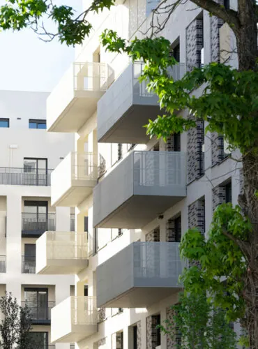immeuble avec des garde-corps tôlés perforés passant devant la dalle, modèle minimal